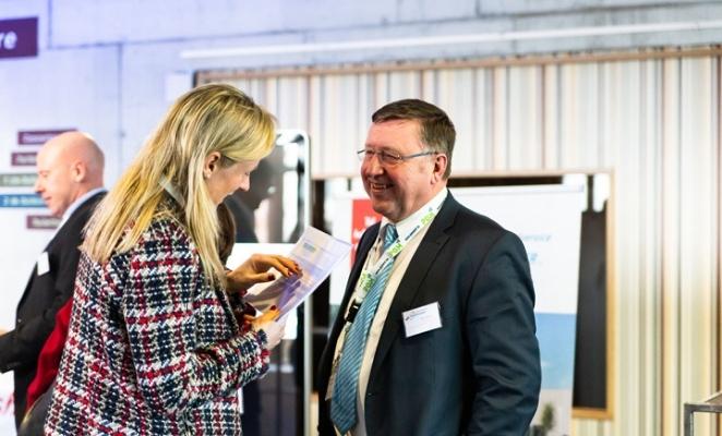 Two people engaged in a conversation at an event venue.