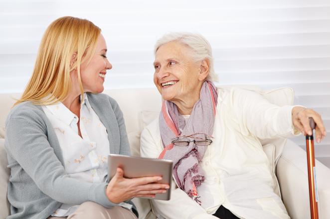 Elderly lady smiling to her caregiver