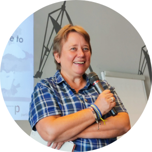 Portrait photo of Nathalie Verschelde holding a microphone. 