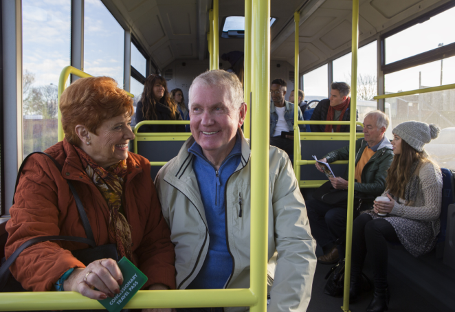 Two elderly people sitting on the bus