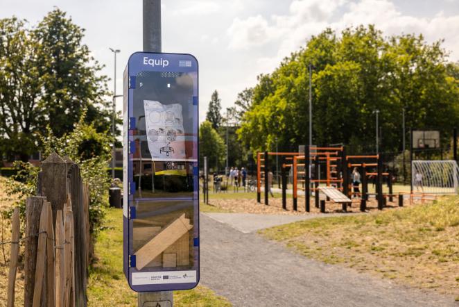Photo of sport sharing station containing games, stationed next to a playground
