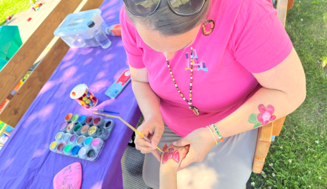 Woman paints hand of child