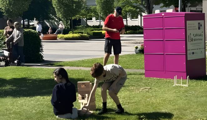 Children play with borrowed toys next to sharing station