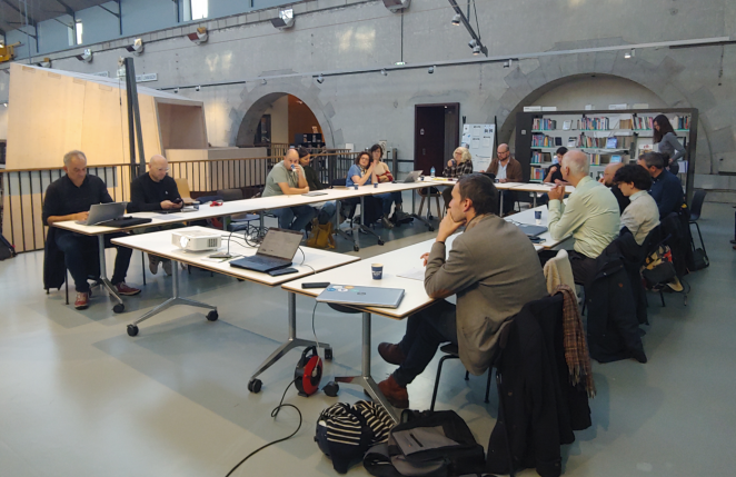Partners sit around a table for the discussion of Day one of the partners meeting in Brest