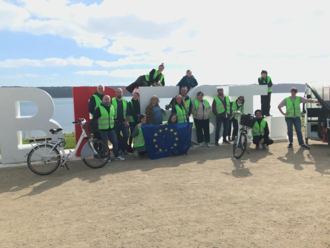 The SMALL partners pose in front of an installation spelling Brest. They're all wearing high visibility vests because they were in the middle of a cycling tour of the city