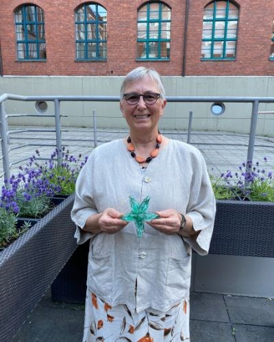 Ingrid Kürsten holding the iconic glass starfish.