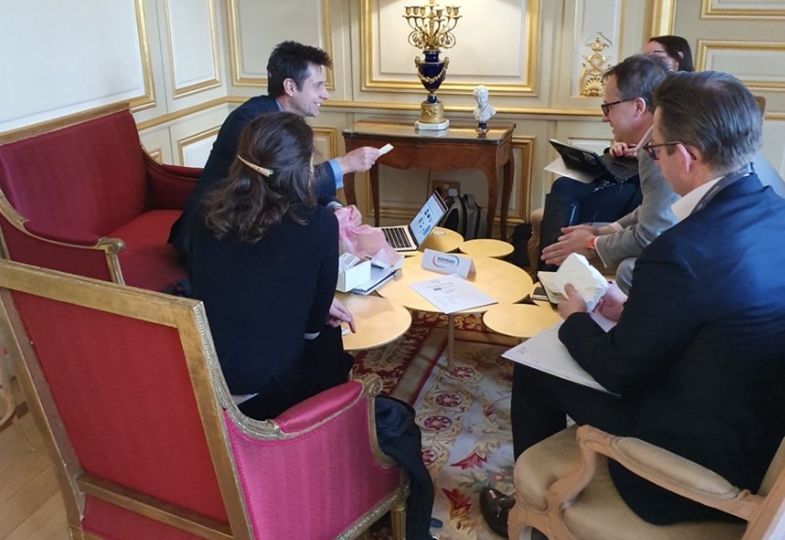 Small group of people seated in armchairs around a small table at a Meet-the-Buyer event