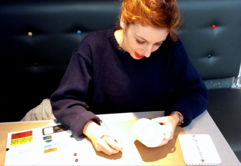 Young lady painting pottery