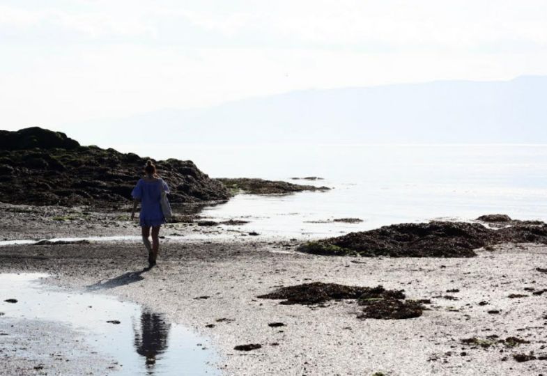 Person walking on a deserted beach in clement weather