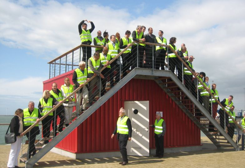 A large group of people wearing yellow safety vests gathered on a staircase.