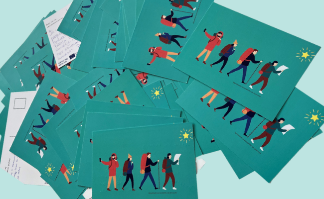 A pile of postcards showing people hiking.
