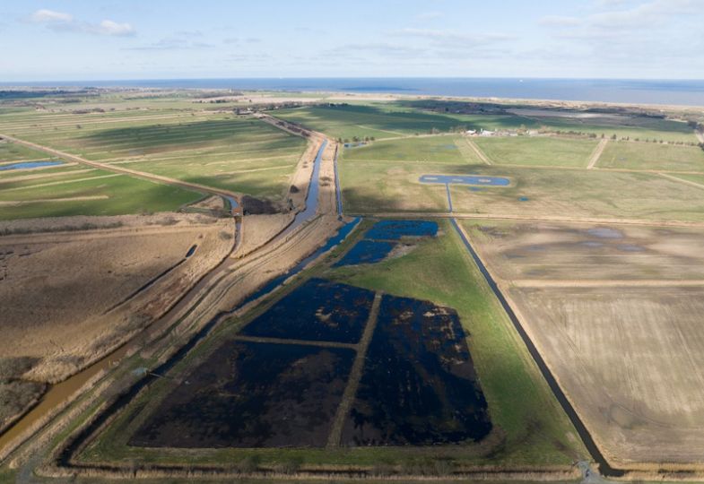 Aerial photo showing a green moor landscape with a large wet farm area.