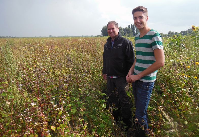 Two smiling farmers in a golden field.