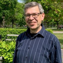 Professor Per-Eric Lindgren in a green park with trees, hedgees, and benches.