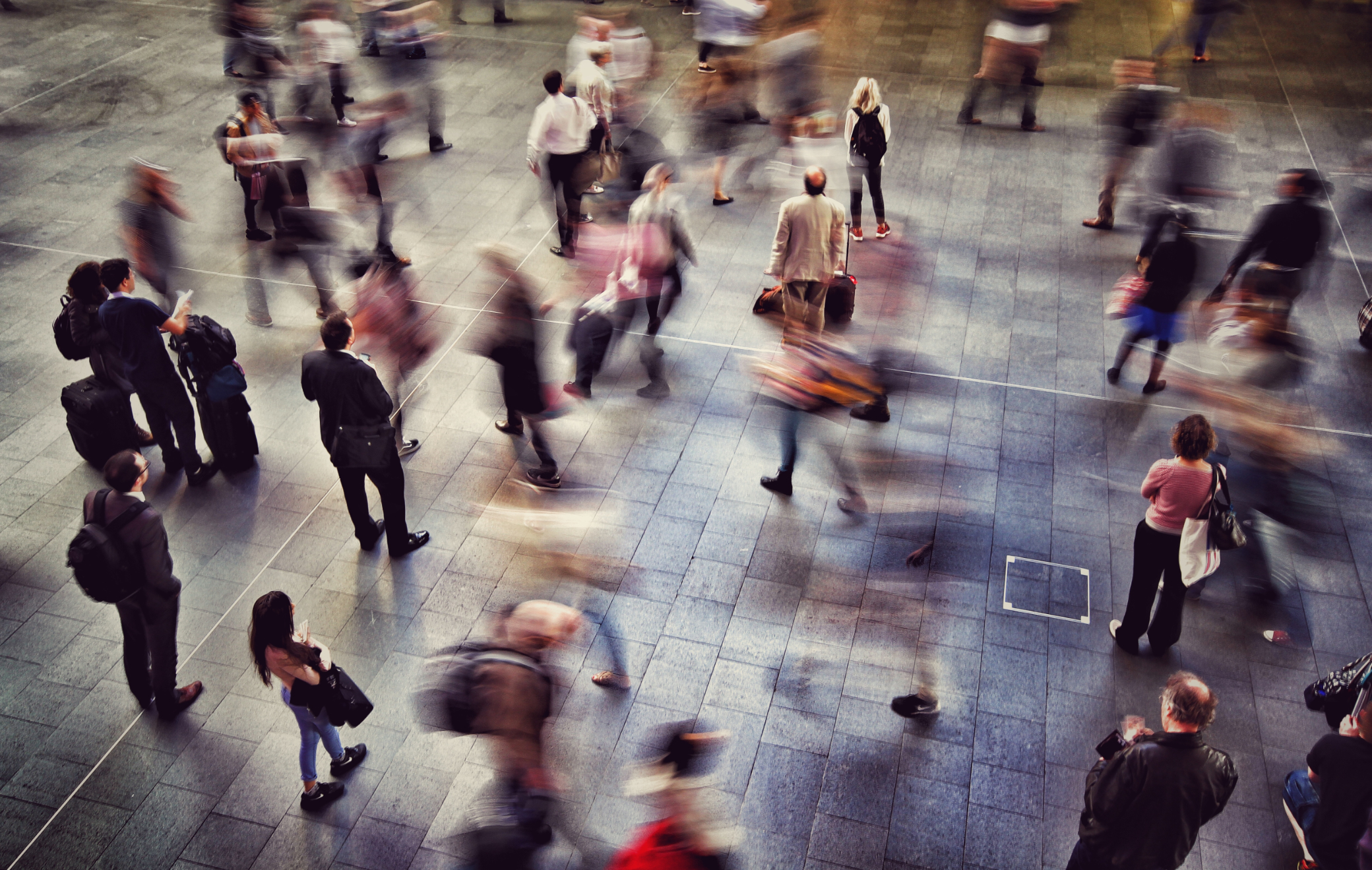 Image of passengers, commuters, and business travelers rushing during a busy moment in a city