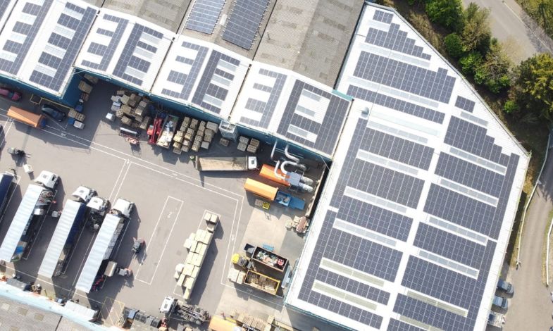 Large garage covered in roofotop solar panels viewed from above.