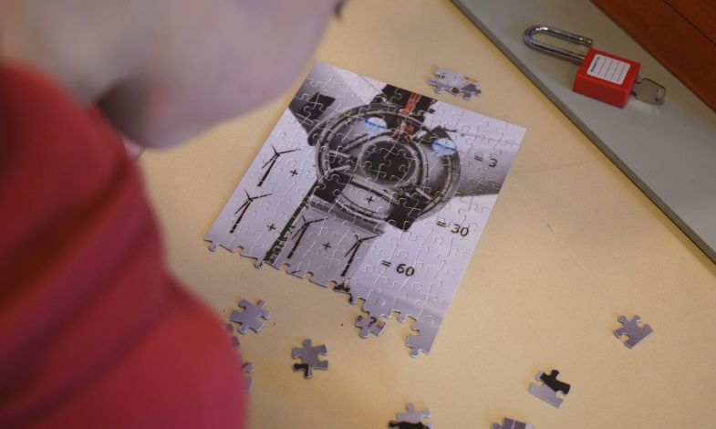 A child laying a puzzle showing a part of a wind turbine. 