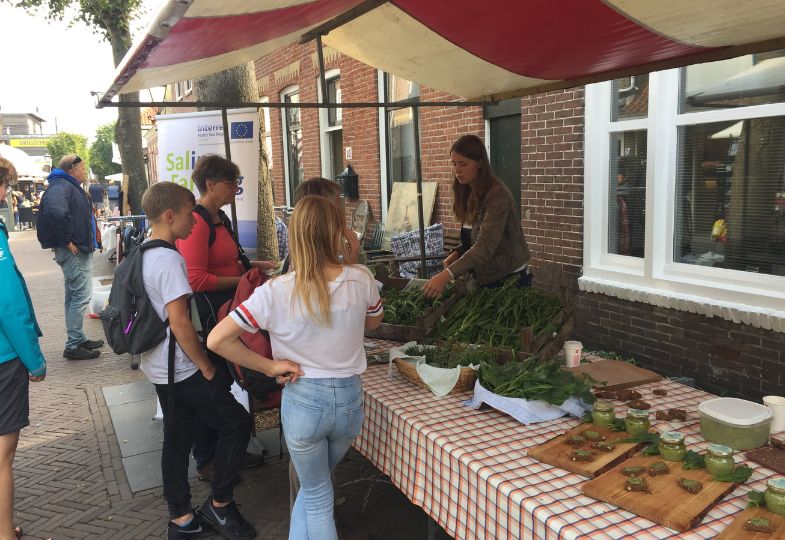 People visiting a booth for tasting salt-grown produce.