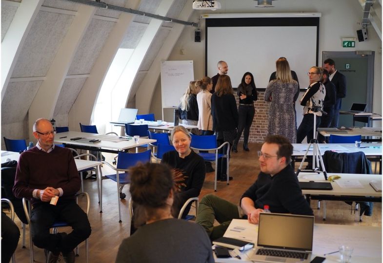 People in two groups of conversation in a large room.