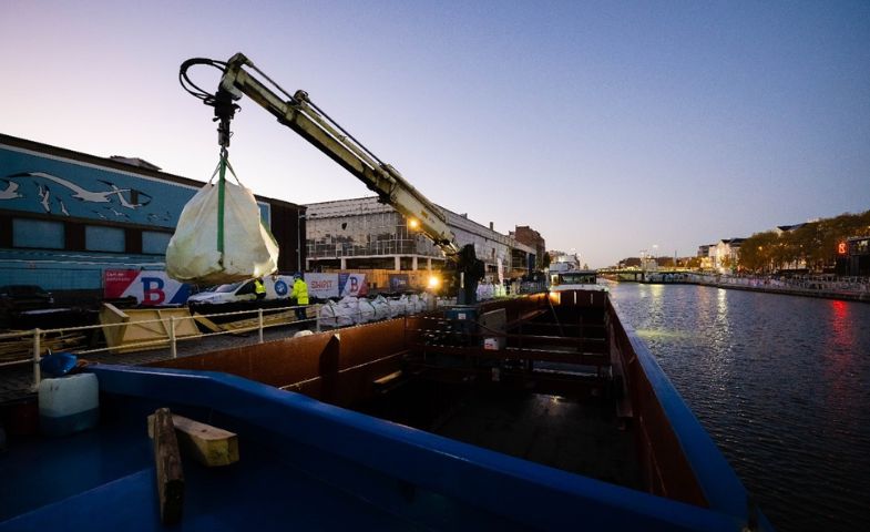 A large crane at a harbour against a blue night sky.