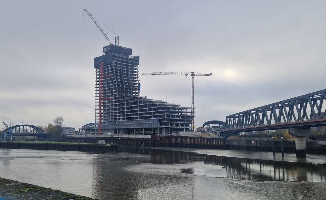 A very tall tower, half-built, in raw concrete.