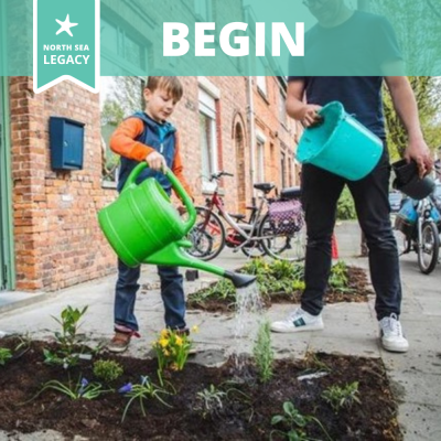 A child watering a small flowerbed created on the pavement.