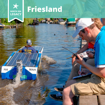 A solar boat racing a long the river, with onlookers seated on the brink.