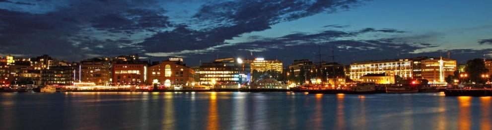 Seaside city at night, with lots of city lights shining into the water.