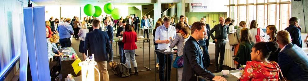 Conferencegoers engaging in conversations during a break.