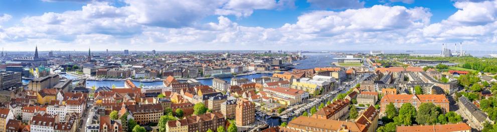 Aerial photo of copenhagen against a cloudy blue sky.