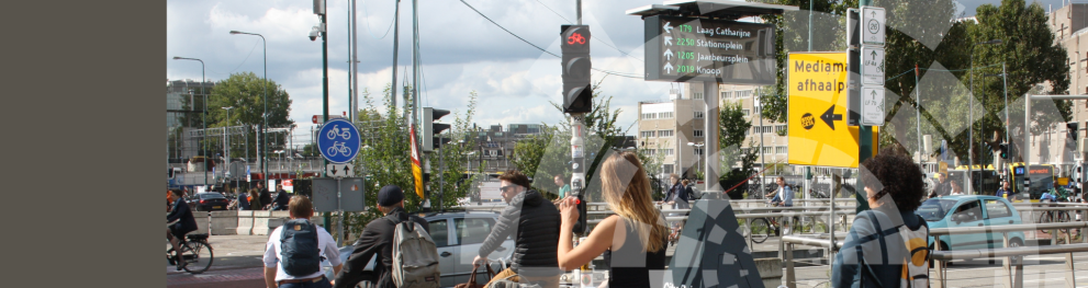 Cyclists at bike traffic light with bike parking displayed on nearby screen