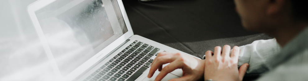 A person sitting by a computer presenting.